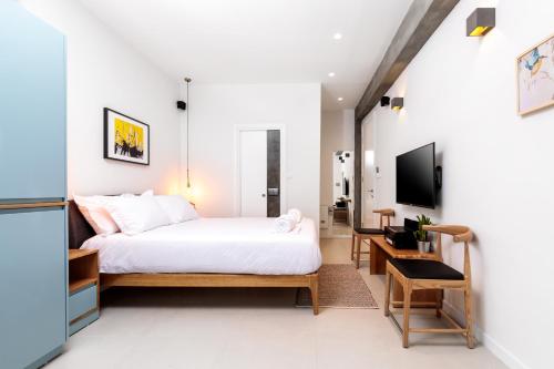 a bedroom with a bed and a desk and a tv at Emanuel Boutique in Jerusalem