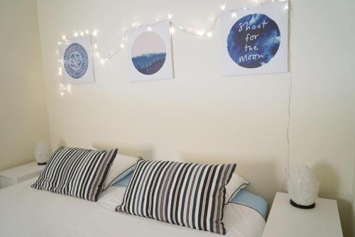 a bedroom with a bed with pillows and pictures on the wall at Balcón del Mar - Playa San Juan in Guía de Isora