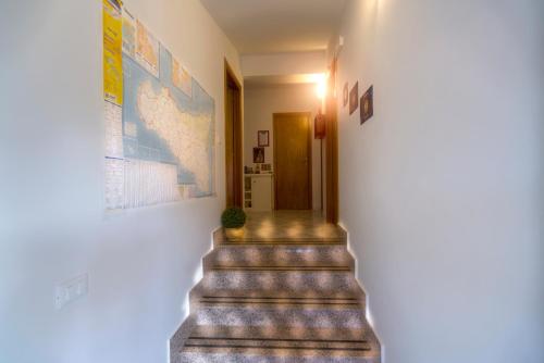 a hallway with stairs and a map on the wall at B&B Gàttina in Naso