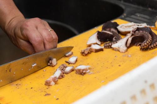 a person cutting up mushrooms on a table with a knife at Hotel Paradiso in Grottammare