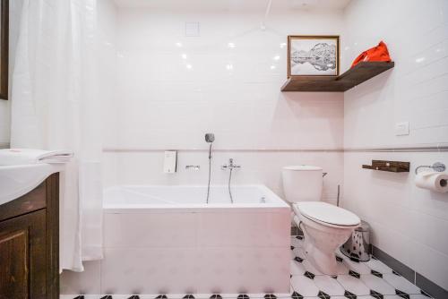 a bathroom with a tub and a toilet and a sink at Revelton Studios Karlovy Vary in Karlovy Vary