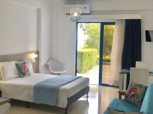 a bedroom with a bed and a sliding glass door at Governors Beach Costas Apts in Governor's Beach