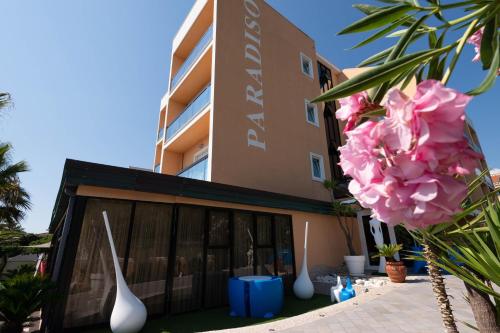 a building with vases and flowers in front of it at Hotel Paradiso in Grottammare
