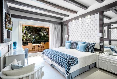 a bedroom with a king sized bed and a balcony at Forte Village Resort - Il Castello in Santa Margherita di Pula