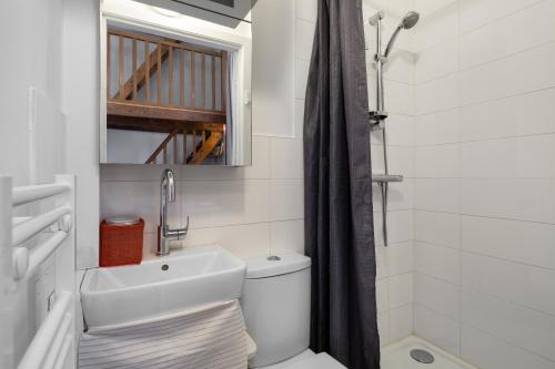 La salle de bains est pourvue d'un lavabo, de toilettes et d'un miroir. dans l'établissement Le Petit Mont by Cocoonr, à Rennes