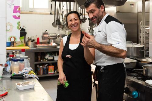 a man standing next to a woman in a kitchen at Hotel Paradiso in Grottammare