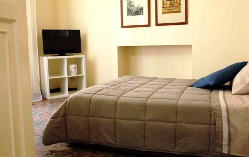 a bedroom with a bed and a flat screen tv at Dimora del sole in Catania