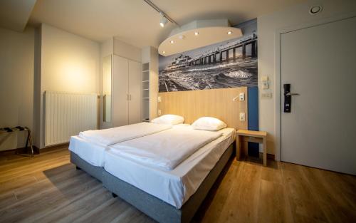 - une chambre avec un grand lit orné d'une peinture murale dans l'établissement Hotel Paradisio by WP Hotels, à Blankenberge