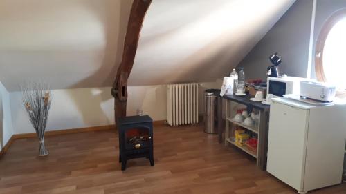 a kitchen with a wood stove in a room at Chambre du Nouvion in Le Nouvion-en-Thiérache