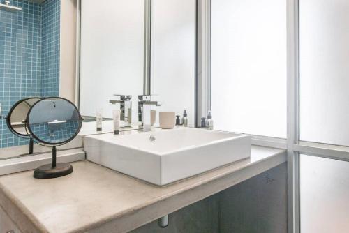 a bathroom with a white sink and a mirror at Houghton Place in Johannesburg