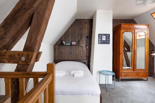 - une petite chambre avec un lit et une armoire en bois dans l'établissement Le Petit Mont by Cocoonr, à Rennes