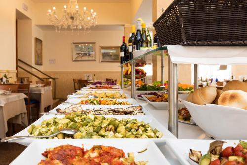 a buffet line with plates of food and bottles of wine at Hotel Paradiso in Grottammare