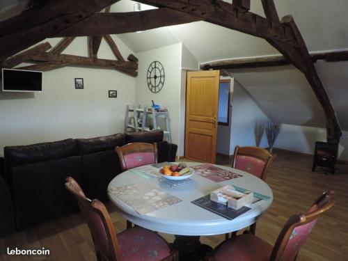 sala de estar con mesa y sofá en Chambre du Nouvion, en Le Nouvion-en-Thiérache