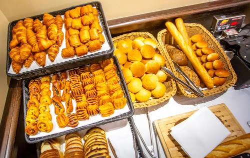 un buffet rempli de plateaux de pâtisseries et d'autres aliments dans l'établissement Hotel Aazaert by WP Hotels, à Blankenberge