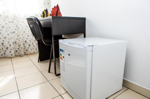 a table and a chair next to a refrigerator at Veda elegant rooms in Fiumefreddo di Sicilia