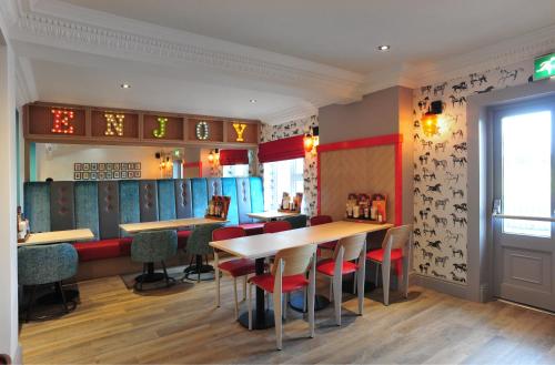 a restaurant with tables and chairs in a room at Weathervane Hotel by Greene King Inns in Stoke on Trent