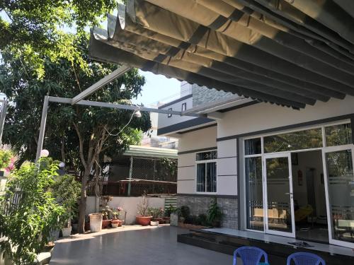 a house with a patio with blue chairs at Nguyễn Kim Motel in Long Hai