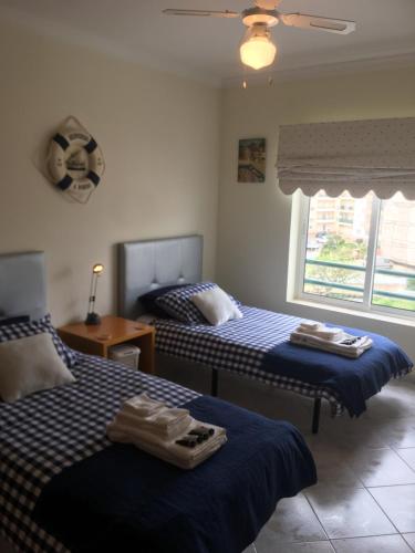 two beds in a room with blue and white at Quiet apartment overlooking the swimming pool in Armação de Pêra