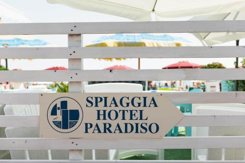 a sign on a white fence with a hotel paradise at Hotel Paradiso in Grottammare