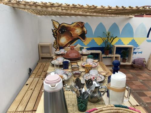 a table with dishes and a horse head on it at Afer Surf Hostel in Imsouane