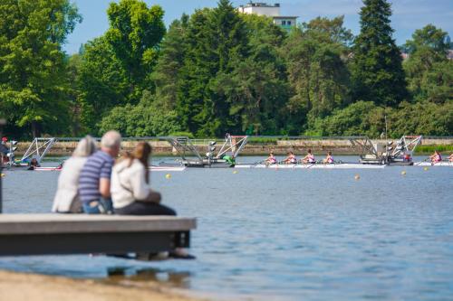 a group of people sitting on a dock in the water at Hôtel ibis Styles Vichy Centre in Vichy