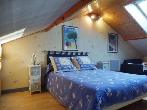 1 dormitorio con 1 cama con edredón azul en Les Aubretias en Fénay