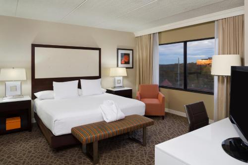 a hotel room with a large bed and a chair at Hyatt Regency Suites Atlanta Northwest in Atlanta