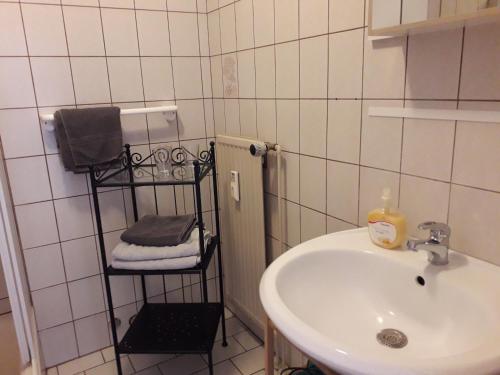 een badkamer met een wastafel en een handdoekenrek bij Pension Norddeicher Straße in Norden