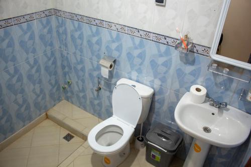 a blue and white bathroom with a toilet and a sink at Afer Surf Hostel in Imsouane