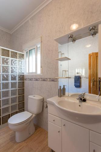 a white bathroom with a toilet and a sink at B&B Los Zuecos in Macisbenda