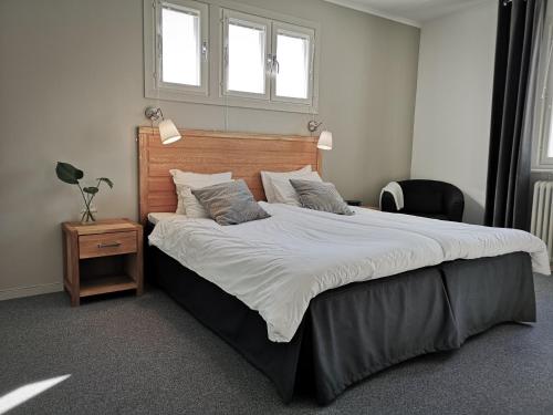 1 dormitorio con 1 cama grande y cabecero de madera en Hotell Apladalen i Värnamo, en Värnamo