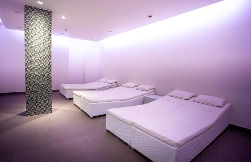 2 Betten in einem weißen Zimmer mit Beleuchtung in der Unterkunft Hotel Aazaert by WP Hotels in Blankenberge
