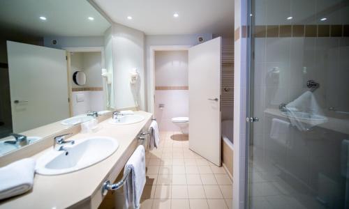 a bathroom with two sinks and a shower at Hotel Aazaert by WP Hotels in Blankenberge