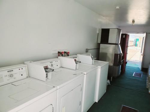 a laundry room with white appliances and a refrigerator at The Budget Inn Express in Sheridan