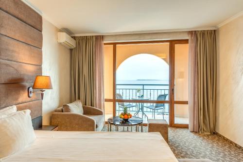 スヴェティ・ヴラスにあるGrand Hotel Sveti Vlasのベッド付きのホテルルームで、海の景色を望めます。