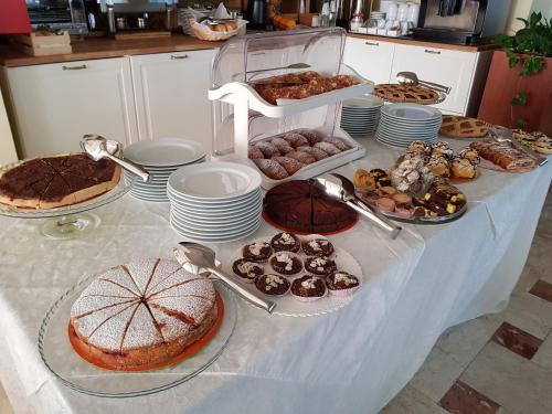 a table with many different types of cakes and pastries at Hotel Beppe in Rimini