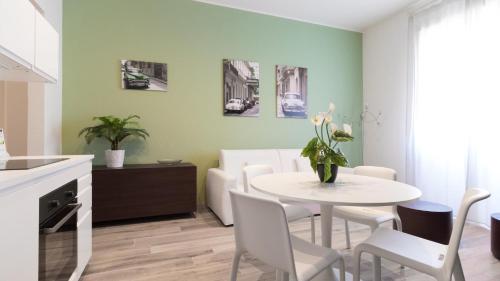 een keuken en eetkamer met een witte tafel en stoelen bij Italianway - Merlo 3 in Milaan