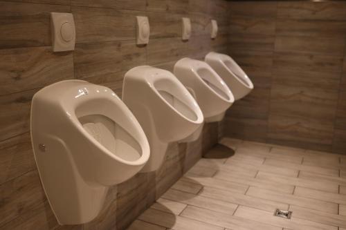 a bathroom with three urinals on the wall at Ilvericher Hof in Meerbusch
