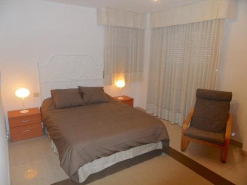 1 dormitorio con 1 cama, 1 silla y 2 lámparas en AUREA, estancia EN SANTA CRUZ, SUPER CENTRICO! en Santa Cruz de Tenerife