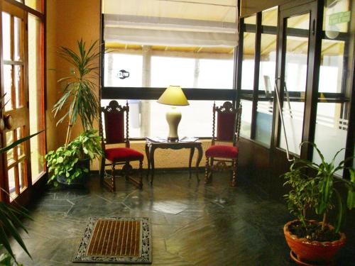 a room with two chairs and a table and a lamp at Hotel City Piriápolis in Piriápolis
