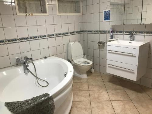 a bathroom with a tub and a toilet and a sink at Nordhagen 17 in Stavanger