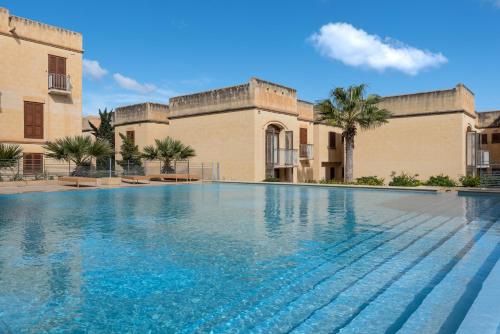 a large swimming pool in front of a building at Harbour Views Duplex Maisonette with Jacuzzi Hot tub in Mġarr