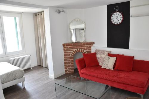 uma sala de estar com um sofá vermelho e uma lareira em 7 Avenue de Provence em Antibes