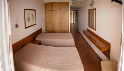 a hospital room with two beds and a hallway at Areia Dourada in Porto Santo