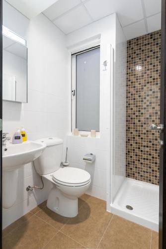 a bathroom with a toilet and a sink and a shower at Harbour Views Duplex Maisonette with Jacuzzi Hot tub in Mġarr