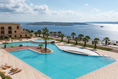 a large swimming pool with a view of the water at Harbour Views Duplex Maisonette with Jacuzzi Hot tub in Mġarr