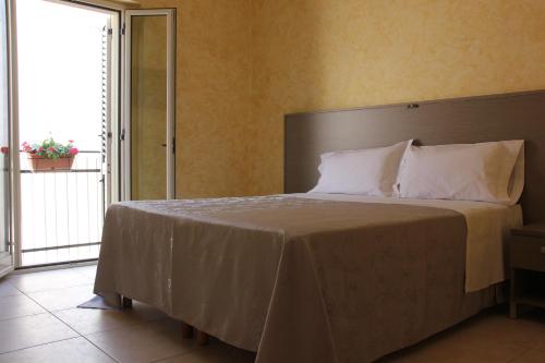 een slaapkamer met een groot bed en een groot raam bij B&B Casa Venezia in Bernalda