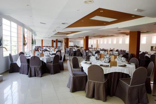 a banquet hall with tables and chairs in a room at Hotel Rio Piedra in Nuévalos