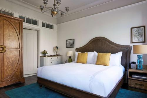 a bedroom with a large white bed with yellow pillows at The Beekman, A Thompson Hotel, by Hyatt in New York