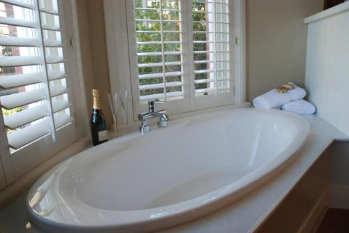 a large white tub in a bathroom with a window at St Leonards Lodge in Dunedin
